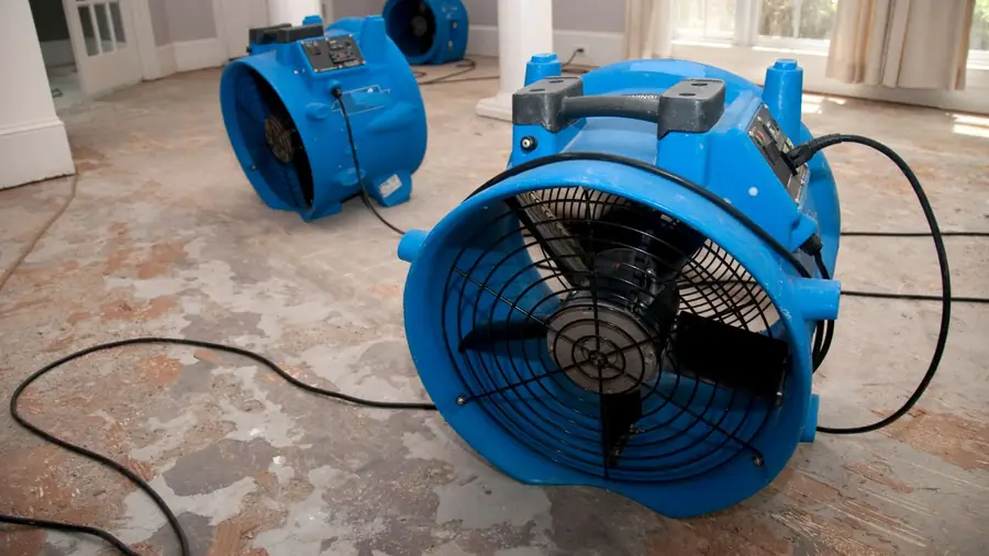 Large blue air mover running on a damp floor