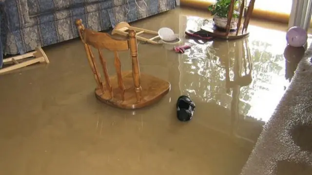 Flooded room with a chair sitting in standing water